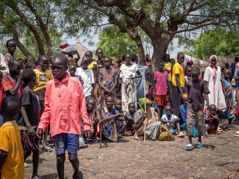 Người lớn và trẻ em Nam Sudan tập trung dưới bóng cây trong khu làng
