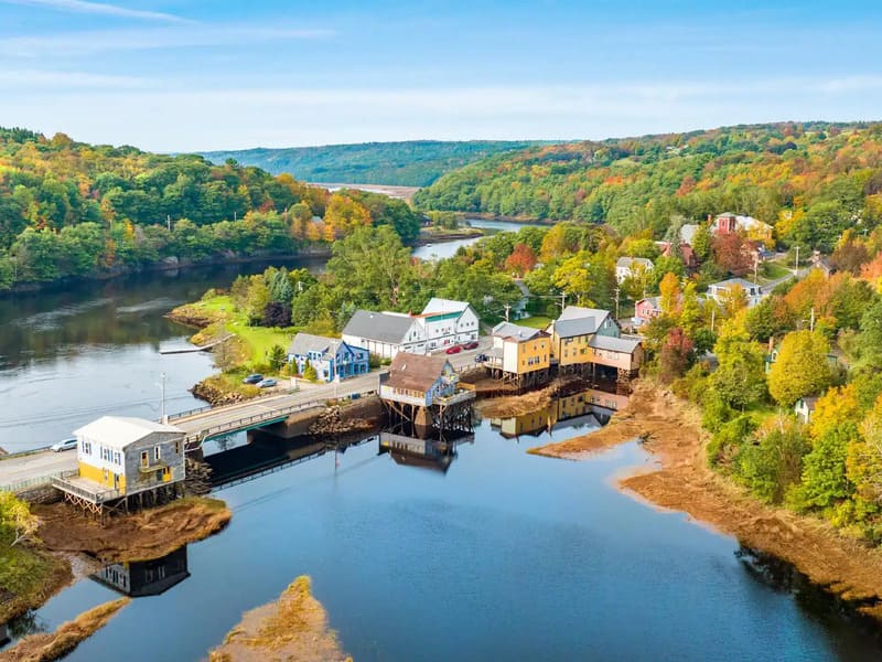 Khu dân cư ven nước ở Nova Scotia với cầu, bến cảng và rừng cây chuyển màu nhìn từ trên cao