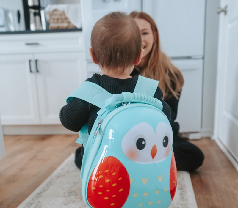 minh họa: Một người mẹ đang dùng tay kiểm tra chất liệu vải của chiếc ba lô trẻ em, góc chụp cận cvào bề mặt vải dù và nhựa EVA 3D